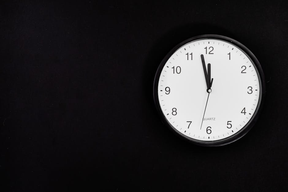 Black Round Analog Wall Clock On Black Background